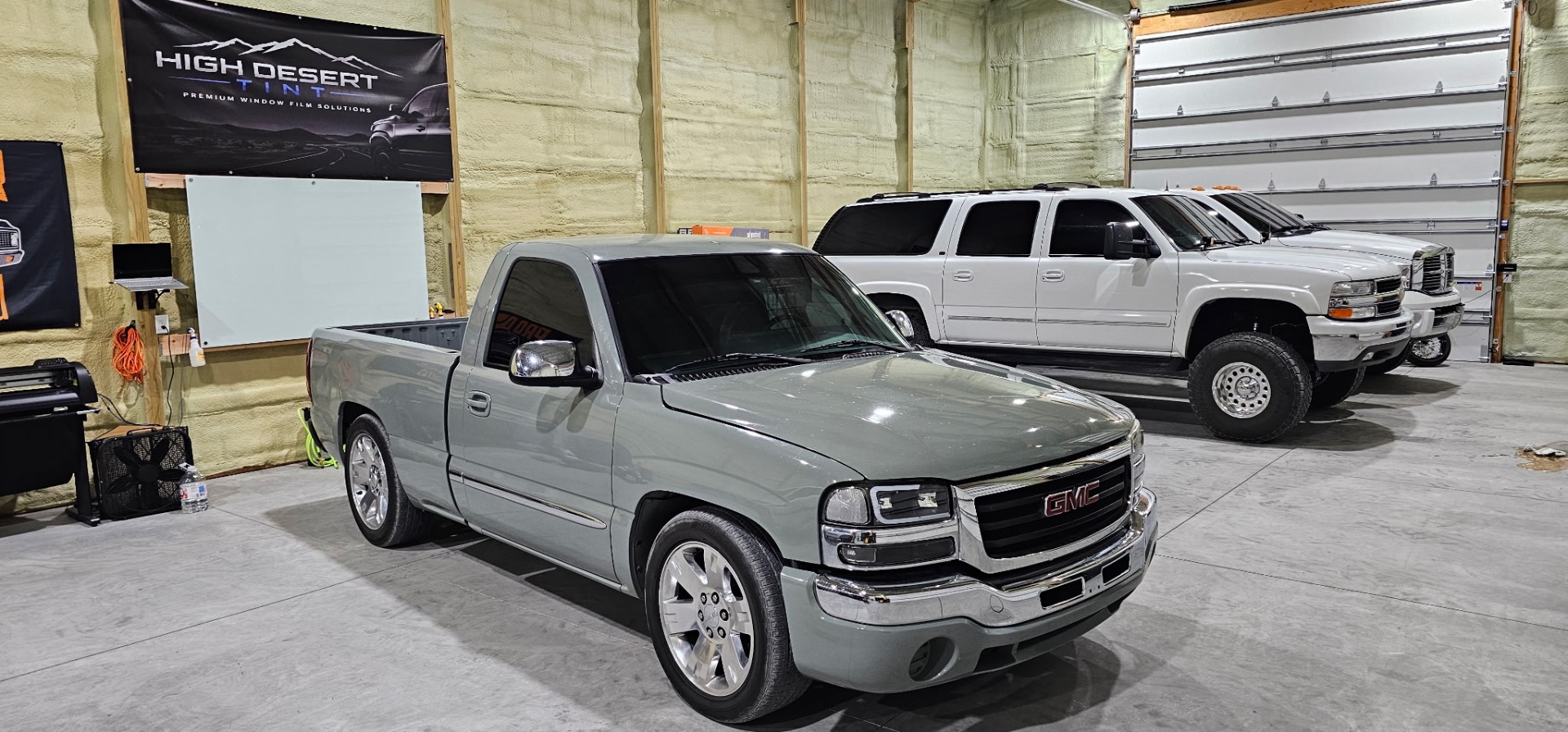 Sage green GMC Sierra single cab with fresh window tint inside the High Desert Tint bay