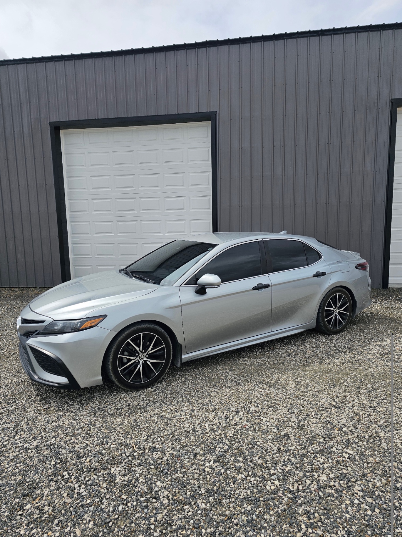 Silver Toyota Camry with premium window tint in front of the shop