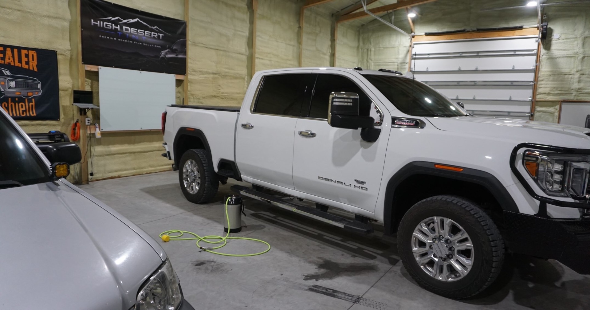 White GMC Sierra Denali HD with premium window tint inside the High Desert Tint bay