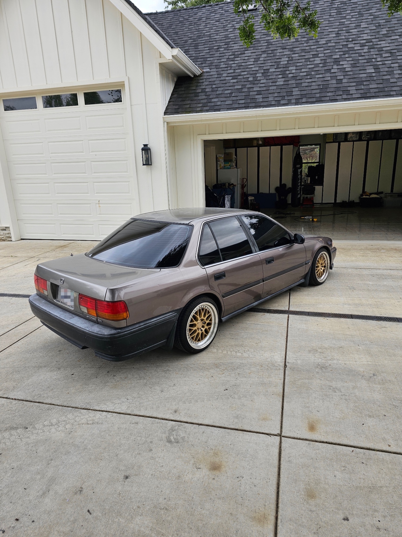 Rear angle of tinted Honda Accord in driveway