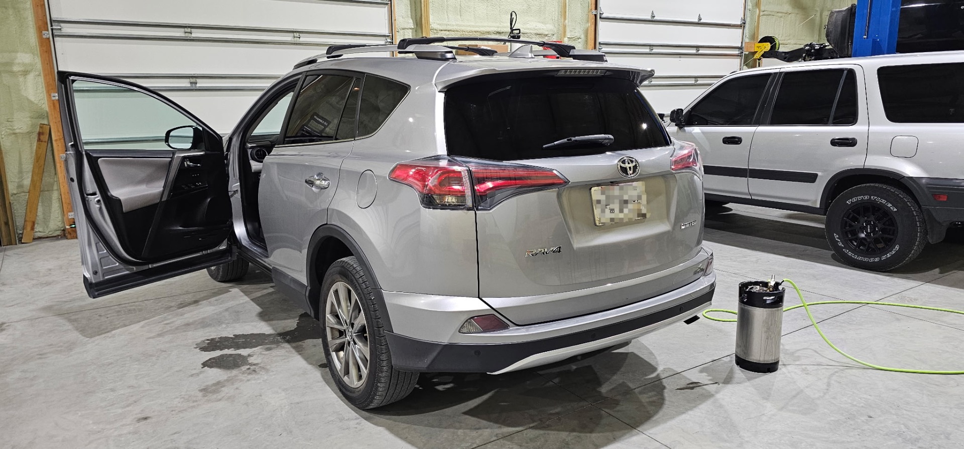 Silver Toyota RAV4 Limited with fresh window tint installed in the shop
