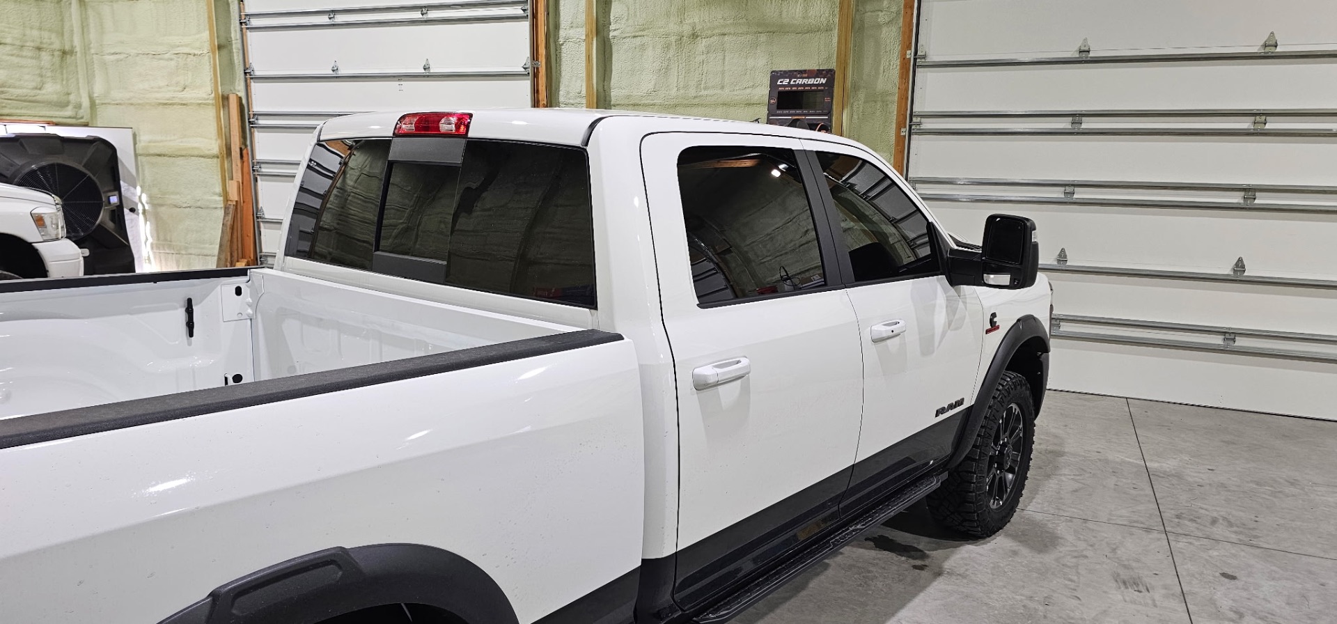 Rear passenger side of a white Ram 2500 showing fresh dark window tint